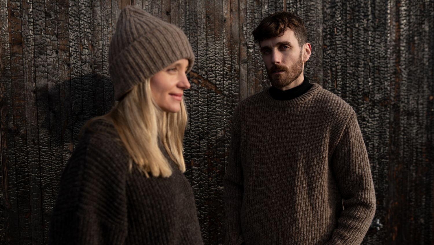 Two people wearing brown knitwear.