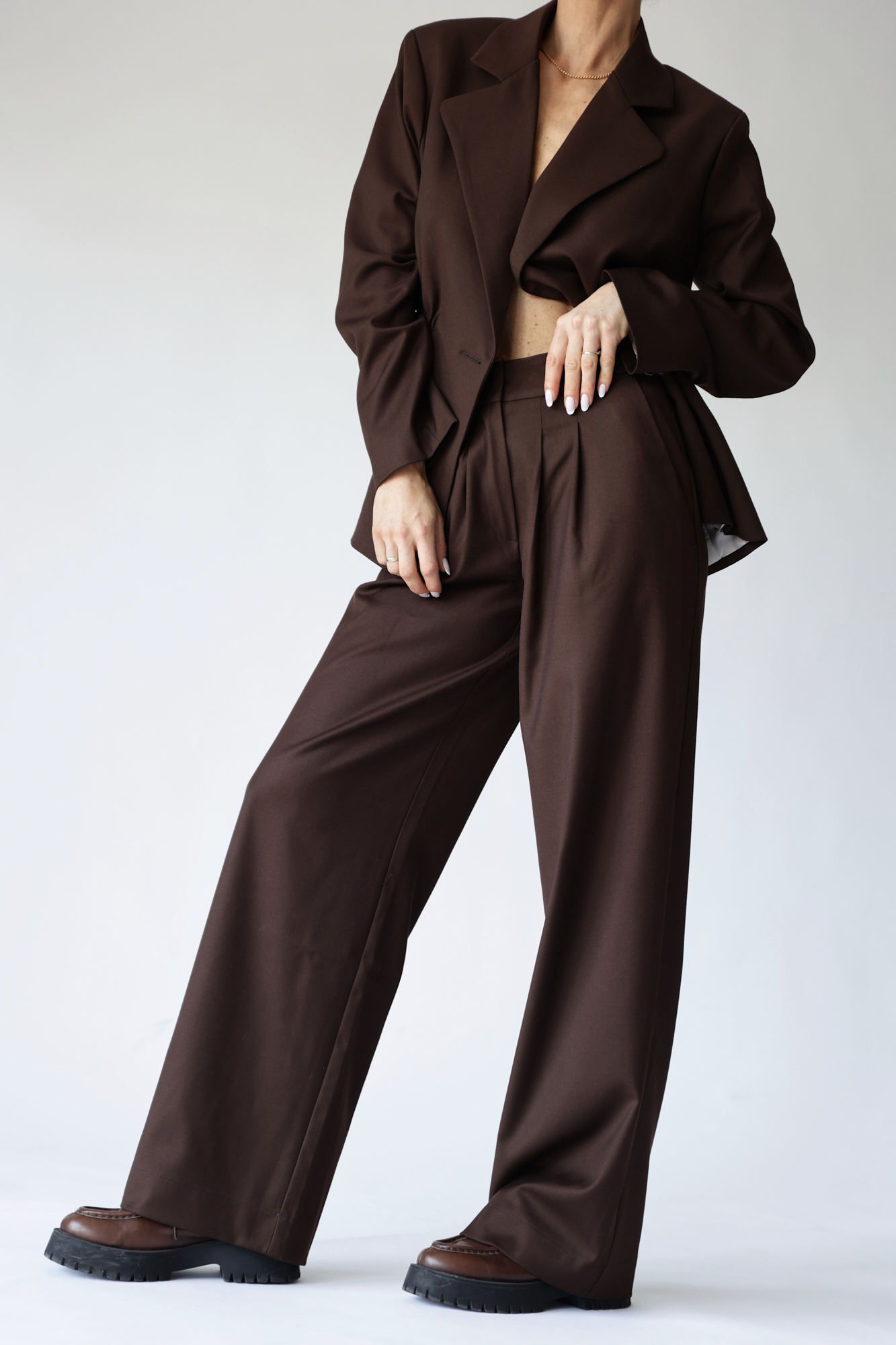 Person wearing a brown suit on a white background