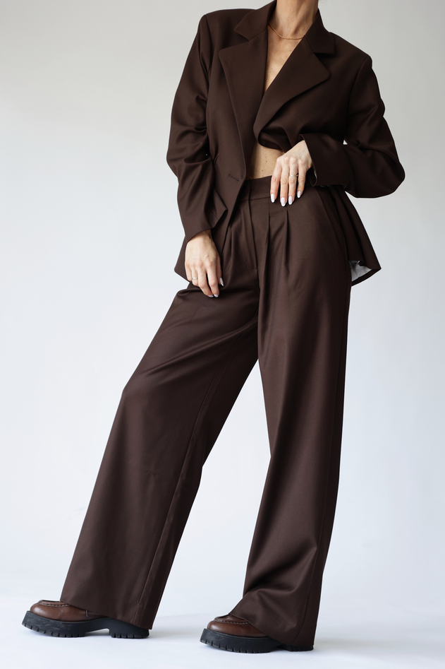 Person wearing a brown suit on a white background