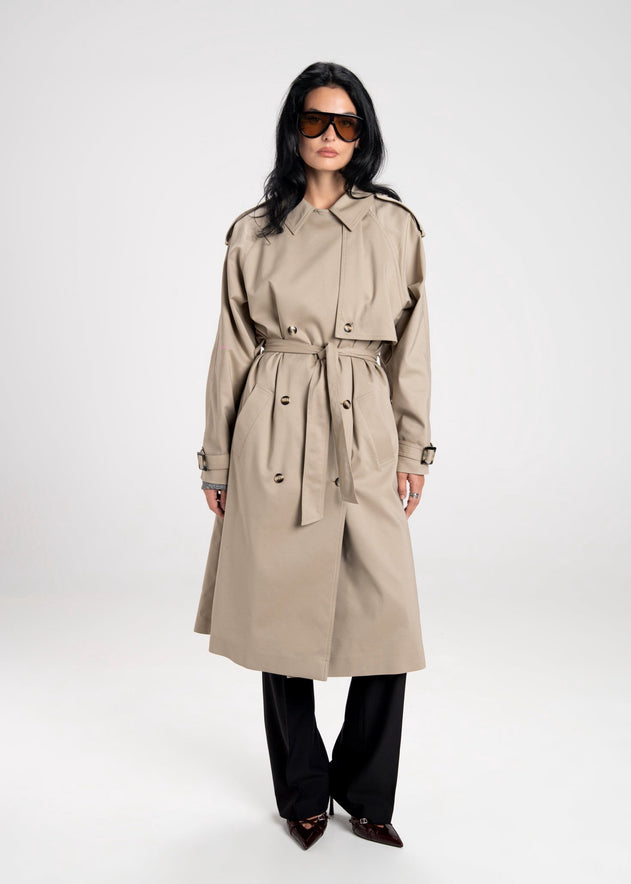 Woman wearing a beige trench coat on a white background