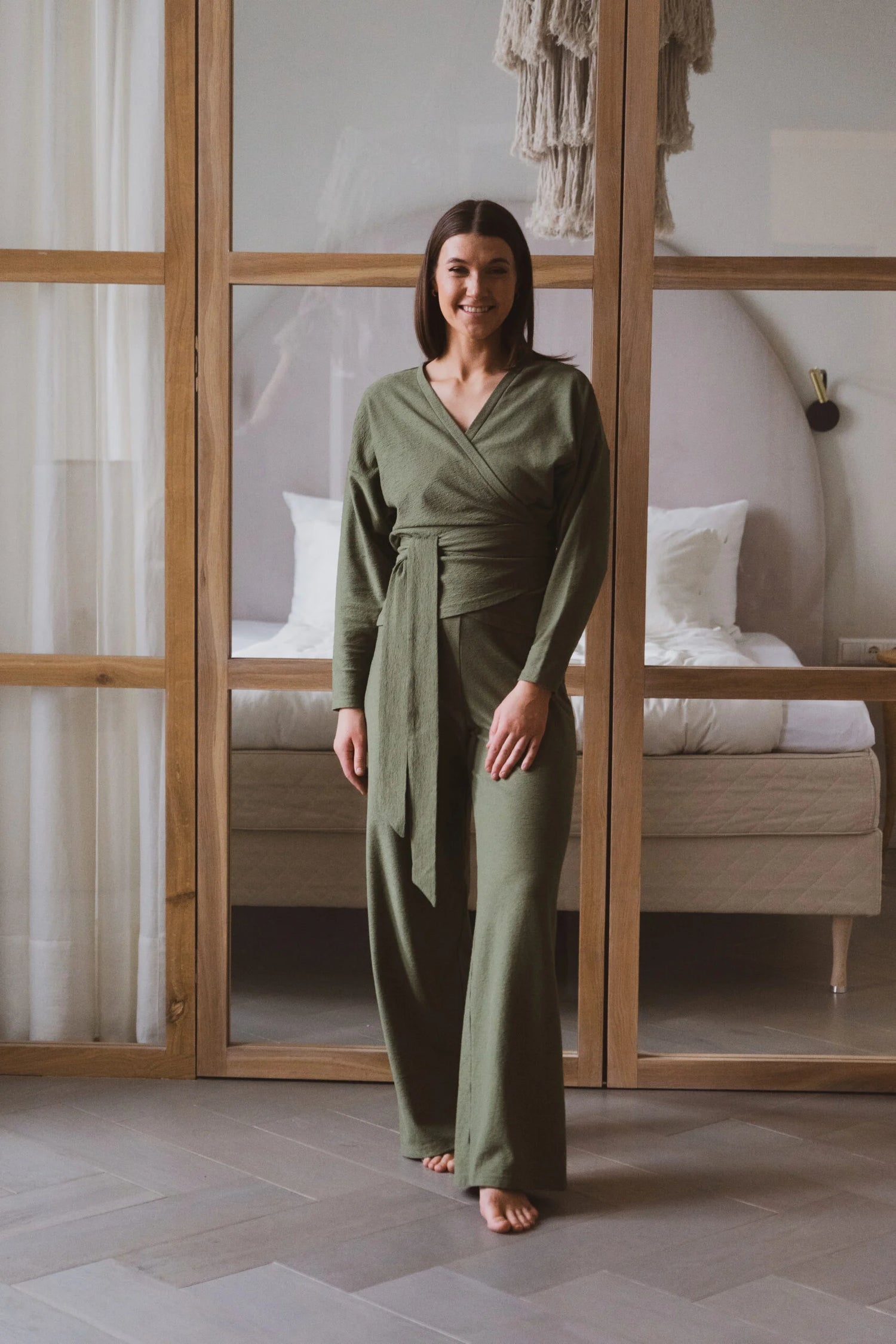 women in front of a glass door wearing a green jumpsuit