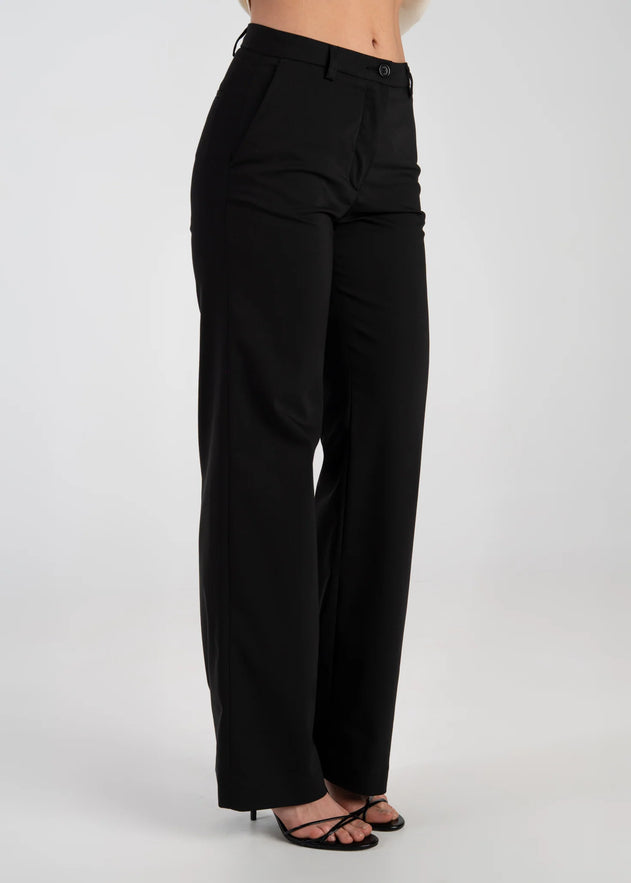 Black pants worn by a person on a white background