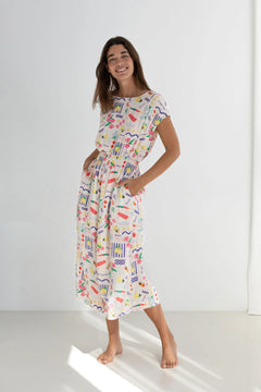 Woman wearing a colorful patterned dress on a white background