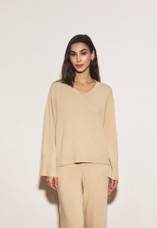 Woman wearing a beige outfit against a white background