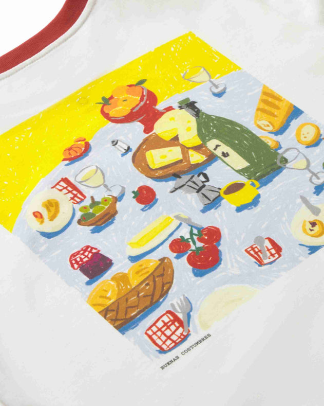 A close-up of a white garment featuring a colorful graphic print of a picnic scene with bread, cheese, tomatoes, wine, and other food items. The brand name 'MORRIS CONTORISH' is printed near the bottom of the graphic.