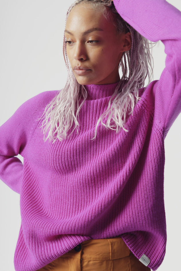 Woman wearing Komodo fuchsia pink merino wool jumper