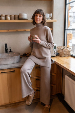 Beige wide-leg merino pants in casual lounge setting