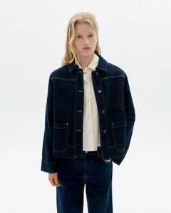 Person wearing a dark blue jacket over a white shirt on a light gray background